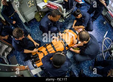 Océan Pacifique (Juillet 17, 2018) - Les Marins affectés aux missiles de l'USS Dewey (DDG 105) sécurité d'une victime simulée sur une civière au cours de la formation médicale dans les bateaux de contrôle central, le 17 juillet. Dewey est en cours aux États-Unis de la flotte de 3ème zone d'opérations. Banque D'Images