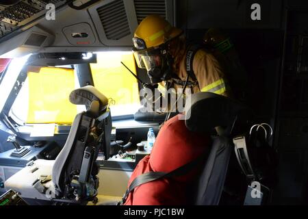 Un pilote américain, affecté à la 424e Escadron de la Base aérienne turque, entre dans le cockpit Airbus A400M pour secourir une victime au cours de l'exercice des pompiers sur la base aérienne de Chièvres, Belgique, le 12 juillet 2018. Banque D'Images