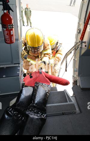 Les aviateurs américains, affecté à la base aérienne 424e Escadron, évacuer un mannequin, simulant une victime, de l'arrière de l'Airbus A400M au cours de l'exercice des pompiers sur la base aérienne de Chièvres, Belgique, le 12 juillet 2018. Banque D'Images