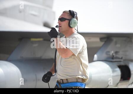 Le sergent-chef. Dallas Cody, 179e Escadron de chasse de l'expéditionnaire, chef de l'équipe communique avec le pilote sur un F-16 Fighting Falcon avant le lancement, le 19 juillet 2018, dans un endroit inconnu en Asie du Sud-Ouest. La 179e EFS est de retourner à la 148e Escadre de chasse à Duluth, Minnesota après un déploiement de près de quatre mois à la 407e groupe expéditionnaire aérienne à l'appui de l'opération inhérents résoudre. Depuis avril, le 179e F-16s de l'EFS a effectué plus de 600 sorties de combat et près de 3 500 heures. Banque D'Images