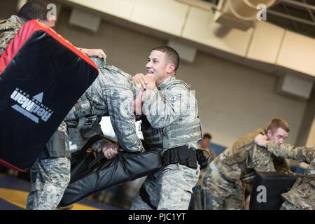 Les forces de sécurité d'un spécialiste (centre) du 193e Escadron d'opérations spéciales les forces de sécurité, New York Air National Guard, se défend au cours d'une multi-agresseur percer 13 Juillet, 2018 à l'école secondaire Middletown de Middletown, Connecticut. Le 193e SOSFS aviateurs utilisé les quatre concepts défensifs (mobilité, remportant l'angle, la distance, de la gestion et de transition) qu'ils ont appris dans les deux jours précédents pour se défendre dans une situation hostile. Banque D'Images