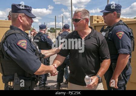 Les membres de la Wisconsin State Patrol simuler l'approvisionnement en eau aux citoyens en détresse dans un scénario de formation pendant 18 PATRIOT North de Fort McCoy, au Wisconsin, le 18 juillet 2018. PATRIOT est un exercice d'entraînement annuel des opérations nationales commanditées par la Garde nationale qui vise à accroître la capacité des collectivités locales, d'État et organismes fédéraux pour coordonner et travailler ensemble en réponse à une catastrophe naturelle ou d'urgence. Banque D'Images