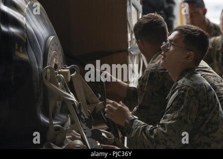 Le Corps des Marines des États-Unis. Connor Morrow, avec le Bataillon de soutien Transport 3d, permet de fixer un système de ravitaillement du corps expéditionnaire de l'hélicoptère pour une chute de l'air dans le cadre de la formation à l'exercice Kodiak Mace Joint Base Elmendorf-Richardson, Alaska, le 16 juillet 2018. Marines de la BST, 3d VMGR-152, et l'Escadron de soutien de l'aile Marine 172 participent à l'exercice. Au cours de l'exercice, le 25 juillet, les Marines sont l'air de précision du système de drop, le fret, et du personnel des parachutages. Banque D'Images