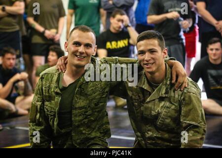 Un soldat de l'armée croate avec fusée d'artillerie "Tempête" de batterie (à gauche) et un soldat de l'armée américaine avec 1er Escadron, 2e Regimet Cavalerie (droit) embrasser après mise en concurrence l'un contre l'autre lors d'une multinationale combatives tournoi avec Battle Group Pologne Bemowo Piskie au domaine de formation, la Pologne le 6 juillet 2018. La Pologne est un groupe de combat, unique coalition multinationale d'États-Unis, Royaume-Uni, croate et soldats roumains qui servent avec la 15e Brigade mécanisée polonaise comme une force de dissuasion de l'OTAN à l'appui de l'amélioration de l'avant la Présence. Banque D'Images