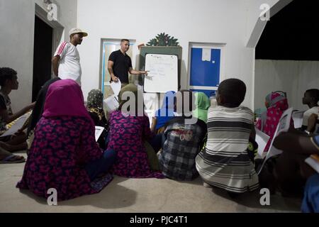 Un soldat de l'Armée américaine à partir de la 404e Bataillon des affaires civiles enseigne l'anglais aux étudiants djiboutiens au cours d'une discussion en groupe anglais Tadjourah, Djibouti, le 10 juillet 2018. Par le biais des principales missions et leader français des groupes de discussion l'équipe des affaires civiles s'emploie à améliorer les relations entre le local national peuplé et les forces américaines, de favoriser une meilleure compréhension des régions d'Obock et de Tadjourah, et coordonner les futures missions de partenariat. Banque D'Images