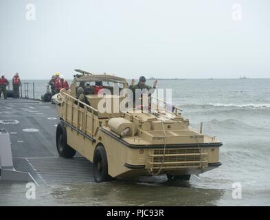 VIRGINIA BEACH, en Virginie (24 juillet 2018) marins affectés au contremaître de l'unité 2 (BMU2) chargement d'un cigare, Amphibie, réapprovisionnement de 5 tonnes de fret (LARC-V) sur l'amélioration du système d'allège la Marine (INLS) Causeway Ferry à Utah Beach à bord d'expéditionnaires interarmées Base Little Creek - Fort Story tout en participant à l'exercice Trident Soleil 18, 24 juillet. Sun 18 Trident est un prépositionnement maritime force (MPF) opération destinée à assurer la formation de personnel de réserve en ce qui concerne le déchargement dans le flux de véhicules militaires et de l'équipement. Banque D'Images