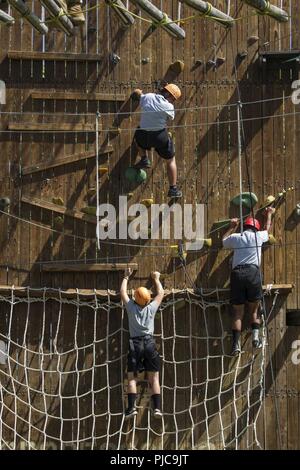 Les candidats dans l'Académie Action Jeunesse Sunburst Class 22 Peloton Firehawks faire leur chemin à travers un système complexe d'obstacles corde en montant à une tyrolienne de terminer, le 19 juillet 2018, à l'Orange County Accrobranche à Anaheim, en Californie. Le parcours donne aux candidats l'occasion de se pousser à la fois mentalement et physiquement, d'instaurer la confiance et de commencer à travailler en équipe tout en restant dans la phase d'acclimatation du défi. Banque D'Images