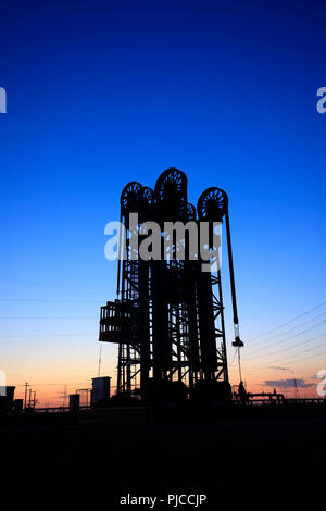 Champ de pétrole, l'unité de pompage de type tour dans la soirée Banque D'Images