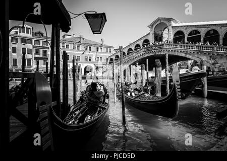 Deux gondoles étant prêt pour un tour sur le Grand Canal à Venise, tandis que les touristes regardant la scène du Pont du Rialto, dans l'arrière-plan Banque D'Images