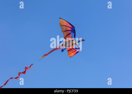 Un cerf-volant en forme de dragon contre ciel bleu profond Banque D'Images