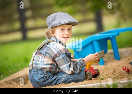 Petit boy en bac à sable. Belle blonde 4 ans garçon dans son bac à sable. Banque D'Images