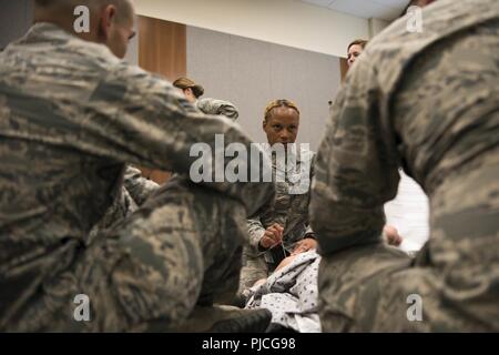 Le sergent-chef de l'US Air Force. Demetris Johnson, une unité de service chef de vol assigné à la 673e Escadron d'opérations internes, indique à 673d Medical personnel Groupe d'effectuer une décompression à l'aiguille pour un pneumothorax sous tension pendant un cours de secourisme en situation de combat at Joint Base Elmendorf-Richardson, Alaska, le 12 juillet 2018. Cette procédure est obligatoire lorsque l'air entre dans la cage thoracique d'empêcher les poumons de l'expansion. L'aiguille libère de l'air, laissant l'expansion pulmonaire et le patient de respirer à nouveau. Banque D'Images