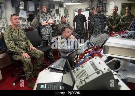 Océan Pacifique (Juillet 20, 2018) La Marine américaine Adm arrière. David A. Welch, commandant, et de Combat Naval Surface Mine Centre de développement de l'écoute une brève mise à jour de commande avec les marins de la Marine royale australienne, le 20 juillet, au cours de l'exercice Rim of the Pacific (RIMPAC). Vingt-cinq nations, 46 navires, 5 sous-marins, et d'environ 200 avions et 25 000 personnes participent à l'EXERCICE RIMPAC du 27 juin au 2 août dans et autour des îles Hawaï et la Californie du Sud. Le plus grand exercice maritime international RIMPAC, fournit une formation unique tout en renforçant et en sustainin Banque D'Images