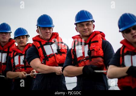 Océan (20 juillet 2018) - Technicien Cryptologic (technique) 2e classe Dillon Fabacher, de West Monroe, Louisiane, maintient le contrôle positif de la ligne de distance et de téléphone à bord du destroyer lance-missiles USS Dewey (DDG 105) lors d'une reconstitution connecté avec la reconstitution de la flotte oiler USNS Henry J. Kaiser (T-AO 187). Dewey est en cours aux États-Unis de la flotte de 3ème zone d'opérations. Banque D'Images