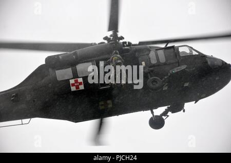 Des soldats américains avec la Compagnie Charlie, 2-104ème bataillon de l'aviation d'appui général conduite sous la pluie la formation treuil à Muir Army Airfield à Fort Indiantown Gap, le 21 juillet 2018. Banque D'Images