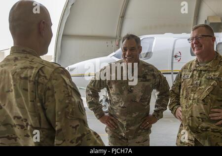 Le lieutenant général de l'ARMÉE AMÉRICAINE Michael X. Garrett, U.S. Army Central (USARCENT), général commandant de l'armée américaine avec des plaisanteries Cpt. Arturo Montanez, gauche, et l'Adjudant-chef 4 Scott Baxter avec l'UC-35 Jet, Détachement de la Compagnie Alpha, 6-52ème bataillon de l'Aviation à Ali Al Salem Air Base, le Koweït, le 21 juillet 2018. Le lieutenant général Garrett a visité la base aérienne pour remercier les membres de l'équipe de vol pour soutenir la mission de l'USARCENT de maintenir une présence durable dans les domaines de l'avant. Banque D'Images