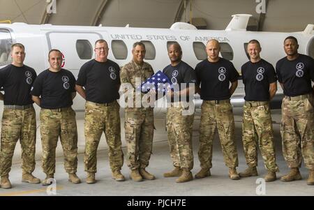 Le lieutenant général de l'ARMÉE AMÉRICAINE Michael X. Garrett, U.S. Army's Central (USARCENT), général commandant la pose pour une photo après avoir été présenté avec un drapeau par des soldats affectés à l'UC-35 Jet, Détachement de la Compagnie Alpha, 6-52ème bataillon de l'Aviation à Ali Al Salem Air Base, le Koweït, le 21 juillet 2018. Le lieutenant général Garrett a visité la base aérienne pour remercier les membres de l'équipe de vol pour soutenir la mission de l'USARCENT de maintenir une présence durable dans les domaines de l'avant. Banque D'Images