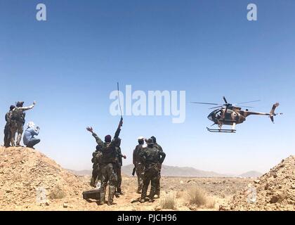 La PROVINCE DE KANDAHAR, Afghanistan (9 juillet 2018) -- Advanced Tactical Air Contrôleurs dans le ministère afghan de l'intérieur du Commandement général des unités spéciales de la Police (GCPSU) et le ministère afghan de la Défense La mission spéciale de l'aile (SMW) vague à un hélicoptère MD-530 SMW comme il fait une passe au cours d'un air-sol, à l'exercice d'intégration gamme Tarnak, province de Kandahar, Afghanistan, 9-10 juillet 2018. (L'OTAN Banque D'Images