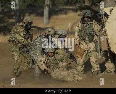 Ingénieur de combat ARMÉE Des soldats de la 374e compagnie du génie, de Concord, Californie, aider un soldat blessé" "retour à l'arrière lors d'une violation à un exercice d'entraînement de soutien au combat (CSTX) à Fort Hunter Liggett, Californie, le 22 juillet 2018. Cette rotation des CSTX traverse le mois de juillet, la formation de milliers de soldats de réserve de l'Armée américaine à partir d'une variété de fonctions pour inclure la police militaire, médicales, chimiques, de la logistique, transport et plus encore. Banque D'Images