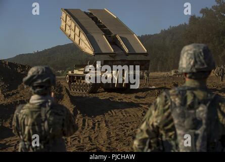 Réserve de l'armée américaine combat engineer Les soldats utilisent une Vehicle-Launched M60 Armored pont à traverser un écart d'une infraction au cours d'un exercice d'entraînement de soutien au combat (CSTX) à Fort Hunter Liggett, Californie, le 22 juillet 2018. Cette rotation des CSTX traverse le mois de juillet, la formation de milliers de soldats de réserve de l'Armée américaine à partir d'une variété de fonctions pour inclure la police militaire, médicales, chimiques, de la logistique, transport et plus encore. Banque D'Images