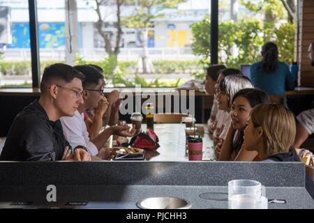 L'Okinawa, Japon, CHATAN- des Marines (Camp Foster converser avec les membres de la communauté locale au cours d'une classe de conversation en anglais 18 Juillet, Chatan dans Okinawa, Japon. Le consulat général des États-Unis à Naha organise des réunions par l'intermédiaire de leurs sites web de médias sociaux, d'inviter toute personne qui veut tester leur anglais. Le seul programme Marine travaille en collaboration avec le consulat des États-Unis pour amener la communauté locale et les Marines ensemble à quatre endroits à travers l'île à tous les deux mois. Banque D'Images