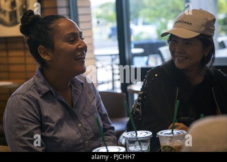 L'Okinawa, Japon, CHATAN- circuit. Krysten Gomez rit avec les membres de la communauté locale à une classe de conversation anglaise 18 Juillet, Chatan dans Okinawa, Japon. Le consulat général des États-Unis à Naha organise des réunions par l'intermédiaire de leurs sites web de médias sociaux, d'inviter toute personne qui veut tester leur anglais. Le seul programme Marine travaille en collaboration avec le consulat des États-Unis pour amener la communauté locale et les Marines ensemble à quatre endroits à travers l'île à tous les deux mois. Gomez est un photographe de combat avec le Siège et l'appui bataillon, Marine Corps Corps d'Pacific-Marine Installations Ba Banque D'Images