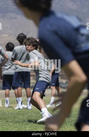 Tim Young, un joueur de football de St. Margaret's Episcopal High School, jette un ballon de football au cours de la pratique avec les Marines avec 1er Régiment de Marines, 1 Division de marines, au Marine Corps Base Camp Pendleton, en Californie, le 19 juillet 2018. L'événement a fourni des Marines et les écoles secondaires locales la possibilité de maintenir et renforcer les relations communautaires. Banque D'Images