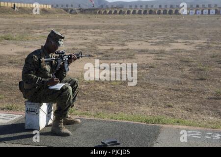 Le sergent du Corps des Marines des États-Unis. Lorenzo Jackson, étudiant, l'adresse au tir de combat Cours de l'entraîneur, écrit dans son carnet d'adresse au tir lors d'un tir réel de familiarisation à Edson, gamme Marine Corps Base Camp Pendleton, en Californie, le 23 juillet 2018. Lorenzo et les autres élèves ont appris à diagnostiquer et corriger les lacunes dans un milieu marin naturel du point de vue, les techniques de respiration et de contrôle de déclenchement. Banque D'Images