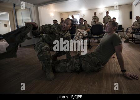 Le capitaine de l'armée américaine Stacey Suttles, un adjoint au médecin affecté à la 404e Bataillon des affaires civiles, Airborne, témoigne d'une technique de soins sous le feu au cours de la lutte contre les cours de sauveteur à la base Militare Italiana di Supporto, Djibouti, le 20 juillet 2018. La co-formation d'une force de coalition CLS a été l'occasion d'enseigner de nouvelles procédures de sauvetage de combat, tout en renforçant les capacités opérationnelles entre les deux nations. Banque D'Images