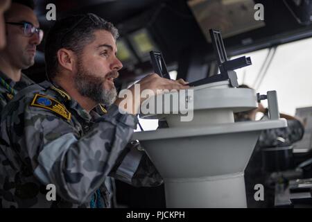 En mer (19 juillet 2018) Lieutenant de la Marine royale australienne Danny Finn, de Stanthorpe, Australie, vérifie la navigation à l'aide d'un polaris sur le pont du navire de débarquement quai hélicoptère HMAS Adelaide (L01) avant d'effectuer un ravitaillement en mer au cours de l'exercice Rim of the Pacific (RIMPAC), le 19 juillet. Vingt-cinq nations, 46 navires, 5 sous-marins, et d'environ 200 avions et 25 000 personnes participent à l'EXERCICE RIMPAC du 27 juin au 2 août dans et autour des îles Hawaï et la Californie du Sud. Le plus grand exercice maritime international RIMPAC, fournit une formation unique o Banque D'Images