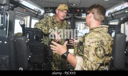 SAN DIEGO (24 juillet 2018) La Marine américaine Adm arrière. Dave Welch, commandant de la Force opérationnelle interalliée (CTF) 177 et la surface de combat naval et Centre de développement de la mine (SMWDC), gauche, parle avec la U.S. Coast Guard Maître de 1re classe Bryan Lopes, jointe à l'équipe d'intervention de la Sécurité maritime de l'USCG (MSRT ouest-W) au cours d'une visite prévue à la Garde côtière des États-Unis Le Secteur de San Diego dans le cadre de l'exercice Rim of the Pacific (RIMPAC) dans le sud de la Californie, le 24 juillet. Vingt-cinq nations, 46 navires, 5 sous-marins, environ 200 avions et 25 000 personnes participent à l'EXERCICE RIMPAC du 27 juin au 2 août dans et arou Banque D'Images