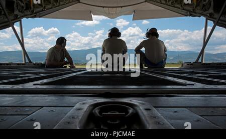 De gauche à droite, les cadres supérieurs de l'US Air Force Airmen Gilbert Ramos, Spencer Koepp, et Brandon PLO, 86e Escadron de maintenance des aéronefs, les chefs d'équipage attendre sur l'arrière d'un C-130J Super Hercules pour une autre à la terre, à Plovdiv, Bulgarie, le 14 juillet 2018. Les membres de la 86e AMXS ont été affectés à l'été 18, un Thrace avant déploiement formation où ils ont maintenu C-130J Super Hercules effectué au cours des exercices. Banque D'Images