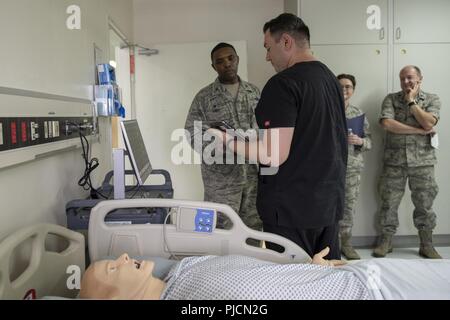 Dominic Trujillo-Hobbs, 374e groupe médical de l'opérateur, le Colonel mémoires simulation Otis C. Jones, commandant de l'Escadre de transport aérien 374e, sur les capacités de l'SimMan 3G et comment elle aide à l'éducation médicale et de formation du personnel médical au cours de l'OMD 374 tour d'immersion à Yokota Air Base, Japon, Juillet 24, 2018. Le laboratoire de simulation forme plus de 800 étudiants, l'accumulation des 1 800 heures de formation sur une base annuelle, des dossiers du personnel à jour sur leurs certifications. Banque D'Images