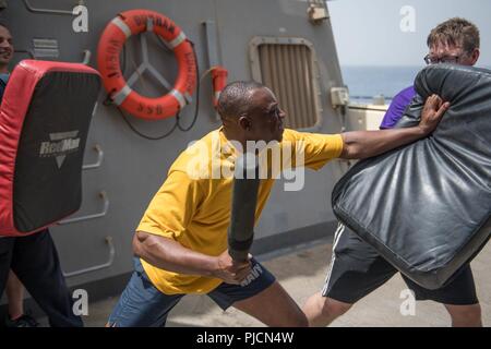 U.S. 5ÈME ZONE DES OPÉRATIONS DE LA FLOTTE (24 juillet 2018) Spécialiste des questions de personnel 1re classe Solomon Fadaka repousse un attaquant après avoir été pulvérisés avec de l'aérosol capsique au cours de formation de base à la force de réaction de sécurité à bord du destroyer lance-missiles USS Jason Dunham (DDG 109). Dunham est déployé sur le 5e flotte américaine zone d'opérations à l'appui des opérations navales pour assurer la stabilité et la sécurité maritime dans la région Centrale, reliant la Méditerranée et le Pacifique à travers l'ouest de l'Océan indien et trois points d'étranglement stratégiques. Banque D'Images