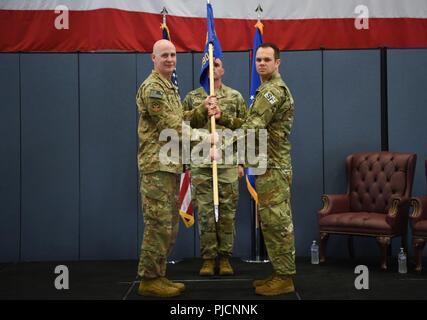 Le Colonel John Grimm, 90e commandant du Groupe des forces de sécurité, passe le guidon au Major Jaroslaw Zrodlowski 790th, commandant de l'Escadron de missiles des forces de sécurité, au cours de la prise de commandement MSFS 790th cérémonie à F.E. Warren Air Force Base, Wyo., le 17 juillet 2018. La cérémonie signifiait la prise de commandement et le transfert officiel de l'autorité à Zrodlowski. Banque D'Images