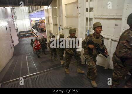 Le HMAS Adelaide Tonguien marines et des soldats avec les forces d'autodéfense du Japon font leur chemin à bord de la Royal Australian Navy landing helicopter dock navire HMAS Adelaide (L01) après la formation au secteur d'entraînement de Pohakuloa dans le cadre de l'exercice Rim of the Pacific (RIMPAC), le 22 juillet 2018. RIMPAC fournit une formation de valeur pour la tâche-organisé, très-capable Marine-Air Task Force au sol et améliore la capacité d'intervention de crise critique de Marines américains dans le Pacifique. Vingt-cinq nations, plus de 45 navires et sous-marins, environ 200 avions et 25 000 personnes participent à l'EXERCICE RIMPAC de J Banque D'Images