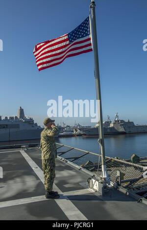 La base navale de SAN DIEGO (23 juillet 2018) - Technicien électronique 1re classe Christopher Barber, de Lenore, Caroline du Nord, salue le drapeau national pendant les couleurs du matin à bord de navires de combat littoral USS Coronado (LCS 4). Coronado est une des neuf lettres homeported à San Diego et est affecté à un escadron de LCS, Commandant. Banque D'Images