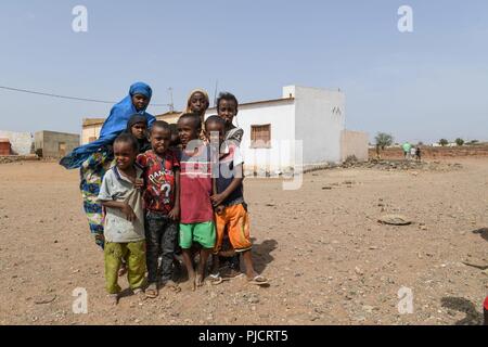 L'enfant djiboutien local posent pour une photo alors que les soldats de l'Armée américaine affecté à la 404e Bataillon des affaires civiles mener une étude de site pour évaluer les projets en cours de construction à Holh Hol, Djibouti, le 24 juillet 2018. Grâce à l'engagement du chef du Bureau des affaires civiles, l'équipe travaille à améliorer encore les relations entre le local national peuplé et les forces américaines. Banque D'Images