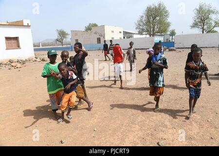 L'enfant djiboutien local jouer tandis que les soldats de l'Armée américaine affecté à la 404e Bataillon des affaires civiles mener une étude de site pour évaluer les projets en cours de construction à Holhol, Djibouti, le 24 juillet 2018. Grâce à l'engagement du chef du Bureau des affaires civiles, l'équipe travaille à améliorer encore les relations entre le local national peuplé et les forces américaines. Banque D'Images