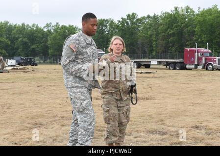 Le s.. Rhonda McQuay, un signal de sous-officiers de l'armée américaine le 690th Port rapide ouvrant, basé à Ft. Eustis, Va., parle avec un soldat tout en soutenant l'Opération Tonnerre à l'Huron Alpena préparation au combat au Centre à Alpena, Michigan, le 22 juillet 2018. McQuay, un Madisonville, Ky., indigène, a travaillé avec le Kentucky Air National Guard's 123e groupe le Plan d'intervention pour l'exploitation d'un groupe Force-Port Ouverture du 22 juillet au 27. L'objectif de la JTF-PO est d'établir une plateforme logistique et la surface du réseau de distribution. Banque D'Images