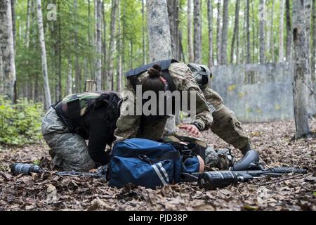 Le personnel du 673d Medical Group se couvrir et protéger le "patient" alors que sous le feu lors de l'application pratique de la situation de combat tactique à l'extrême au cours de Paintball Warrior Joint Base Elmendorf-Richardson, Alaska, le 13 juillet 2018. Le cours est l'occasion pour chaque étudiant de fournir des soins sous le feu, effectuer des soins sur le terrain tactique sur ceux qui sont blessés et exécuter une évacuation tactique. Banque D'Images