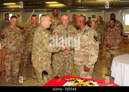 Le Lieutenant-colonel de l'armée américaine Kelvin Swint, droite, commandant du 2e Bataillon, 5e régiment de cavalerie, 1st Armored Brigade Combat Team, 1re Division de cavalerie, serre la main avec le brigadier. Gen. Dragoș Iacob, J7- Chef de la formation et de la doctrine, direction générale de l'avant le découpage de la partie du bataillon d'uncasing cérémonie à Mihail Kogalniceanu, Roumanie, 17 juillet 2018.La cérémonie d'uncasing marque officiellement le début de la 2-5 CAV mission en Roumanie et continue de renforcer le partenariat entre les États-Unis, l'OTAN partenaires et alliés. Banque D'Images