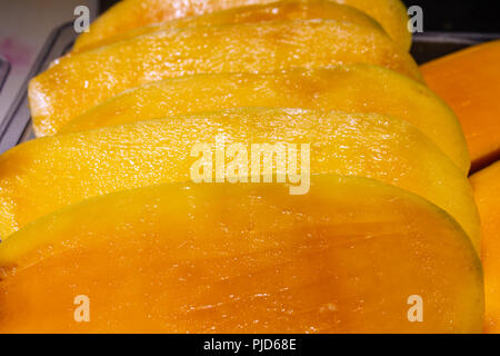 Couper les fruits frais à la mangue sur le comptoir du marché asiatique Banque D'Images