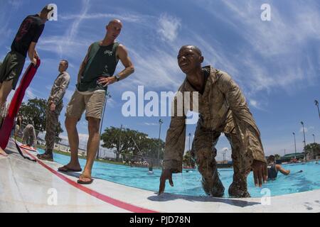 Les recrues du Corps des Marines des États-Unis, avec l'entreprise de Golf, 2e Bataillon, Régiment d'entraînement des recrues, et Oscar Co., 4e Bn., RTR, sort de la piscine en maillot de bain sur Qualification Marine Corps Recruter Depot Parris Island, S.C., 25 juillet 2018. Comme une exigence pour l'obtention du diplôme de qualification, nager sont des recrues pour être testés sur leur capacité à sauter dans les eaux profondes, jeter l'équipement approprié, et l'eau de la bande de roulement dans le plein de services publics. Banque D'Images