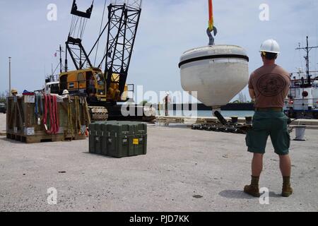 U.S. Navy Seabee plongeurs avec détachement Plongée Construction Charlie (PDTPB) de construction sous-marine l'équipe 2, travailler avec des entrepreneurs locaux pour coordonner le déploiement d'une nouvelle flotte mooring dans l'eau sur l'île de Wake. Terminé les réparations pour les PDTPB émergente Service off-shore de l'île d'alimentation en carburant après forte mer déconnecté une de la flotte des bouées d'amarrage. Les PDTPB est sur le premier arrêt de leurs six mois de déploiement où ils sont offrant des services de construction, d'inspection, de réparation et d'entretien des installations côtières et océaniques à l'appui de la 7ème flotte américaine. Banque D'Images