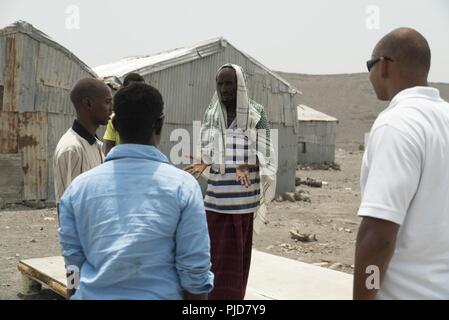 Les soldats de l'Armée américaine affecté à 404e Bataillon des affaires civiles de discuter avec un ancien du village où à mis sur pied une clinique pour traiter le bétail à Galafi, Djibouti, le 16 juillet 2018. La mission d'assistance vétérinaire est destiné à renforcer les capacités des agents de santé animale, d'assurer le bien-être des troupeaux d'animaux, et de renforcer la stabilité économique et agricole, tout en favorisant des relations positives entre les États-Unis et les pays partenaires. Banque D'Images