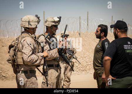 FIREBASE UM JORAIS, IRAQ - Le sergent du Corps des Marines des États-Unis. Omar Jaohar un interprète avec des Groupe de travail air-sol marin, Crise Response-Central parle de commande à des entrepreneurs à base de feu Um Jorais FB (UJ) le 5 juillet 2018. SPMAGTF-CR-CC de Marine a contribué à l'Opération Lance Talon en fournissant la sécurité à FB UJ. Banque D'Images