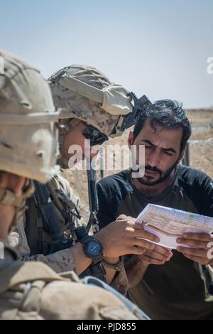 FIREBASE UM JORAIS, IRAQ - Le sergent du Corps des Marines des États-Unis. Omar Jaohar un interprète avec des Groupe de travail air-sol marin, Crise Response-Central parle de commande à des entrepreneurs à base de feu Um Jorais FB (UJ) le 5 juillet 2018. SPMAGTF-CR-CC de Marine a contribué à l'Opération Lance Talon en fournissant la sécurité à FB UJ. Banque D'Images