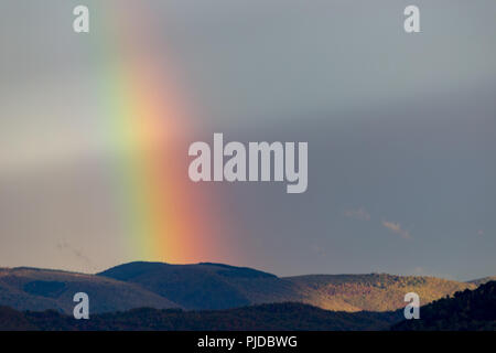 Belle et surréaliste vue d'une partie d'un arc-en-ciel sur certaines collines Banque D'Images