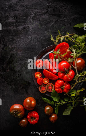 Des tranches de tomate fraîche sur fond noir, copy space Banque D'Images
